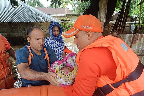 Tripura Floods: An NDRF person carries an infant to safety in a flood-affected area